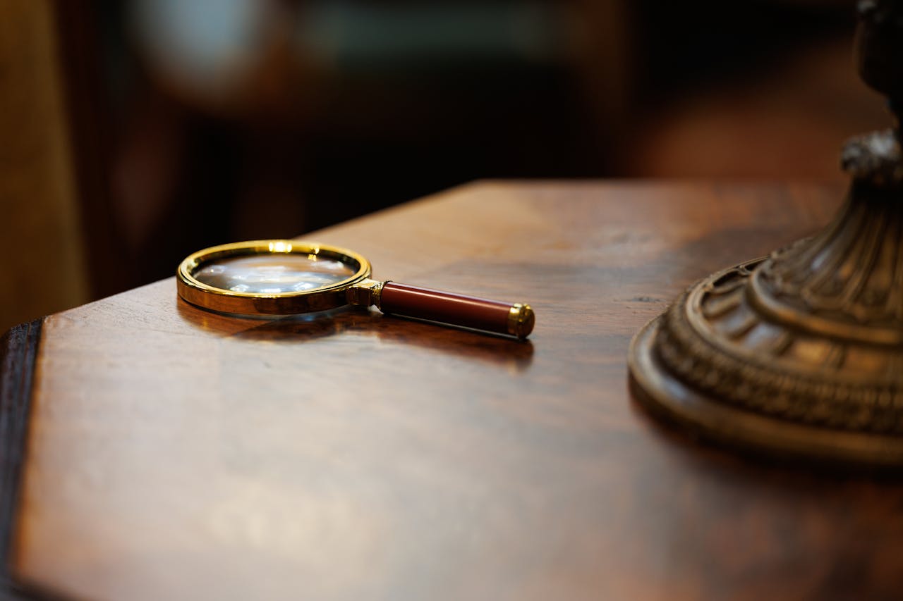 A vintage-style magnifying glass placed on a polished wooden table, exuding an elegant and classic look.