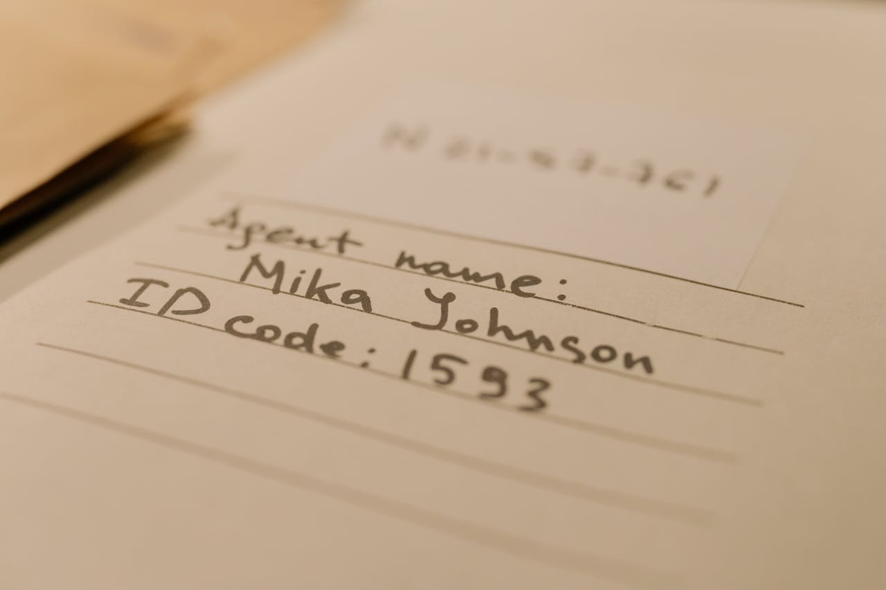 Handwritten document with agent name and ID code, showcasing personal handwritten text.
